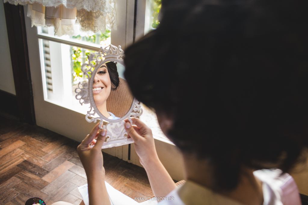 Noiva se olhando no espelho verificando sua maquiagem