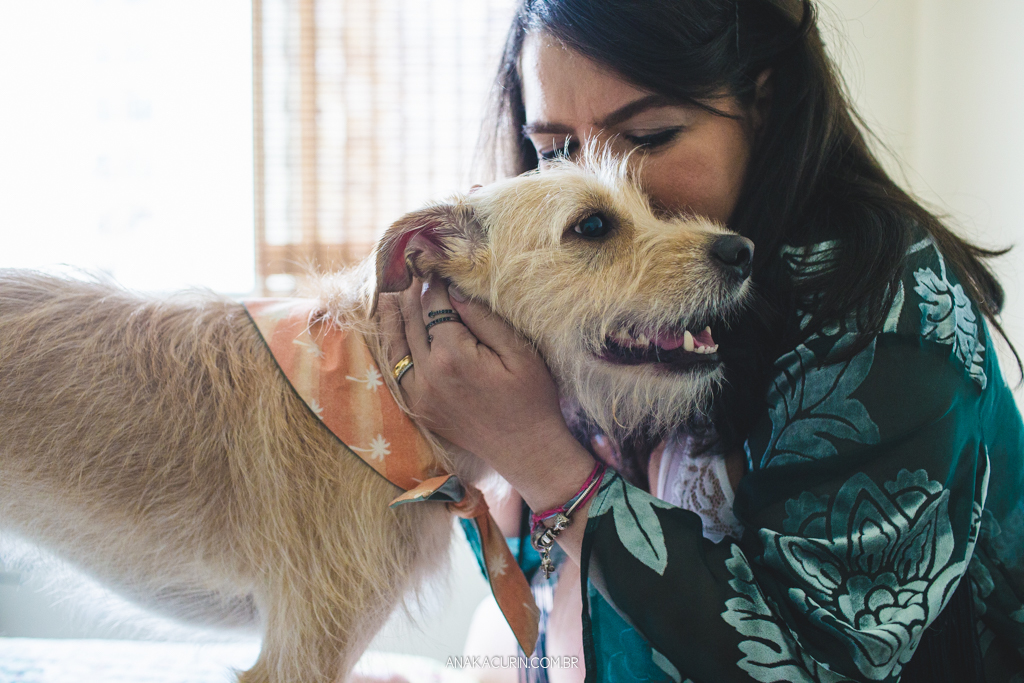 Gestante Flávia e Fábio deitados na cama, namorando com o pet cão Simba ao lado