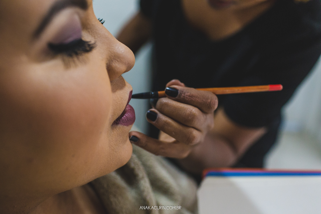 Maquiadora aplicando batom uva na noiva