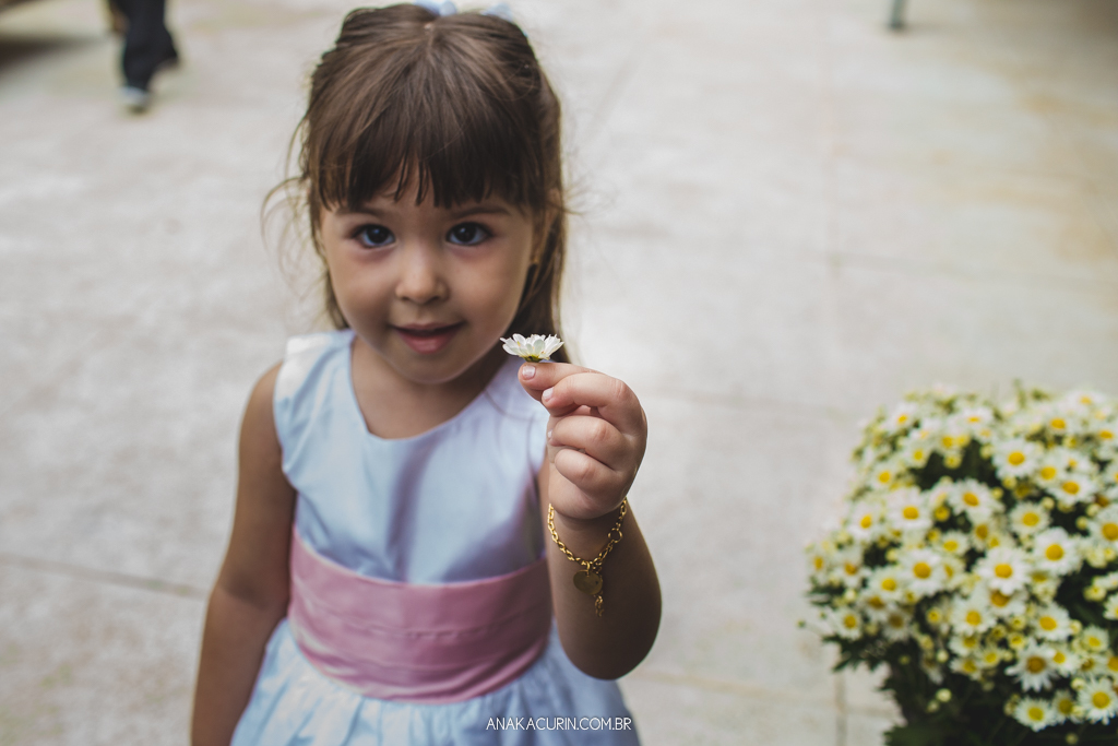 Daminha segurando uma florzinha  de presente para a noiva