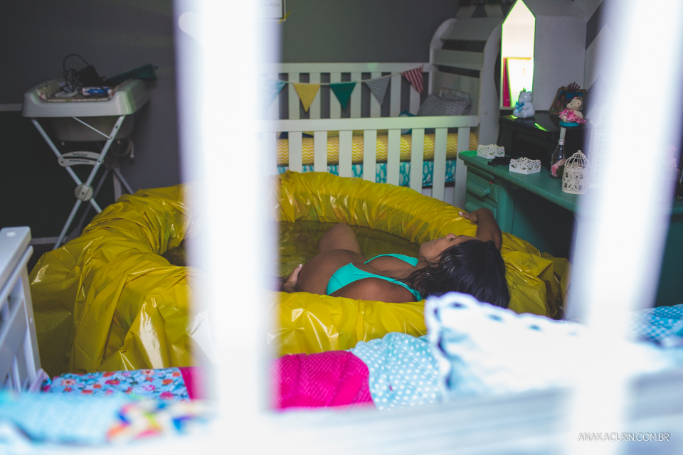 Gestante em trabalho de aprto em casa, mergulhada numa piscina amarela