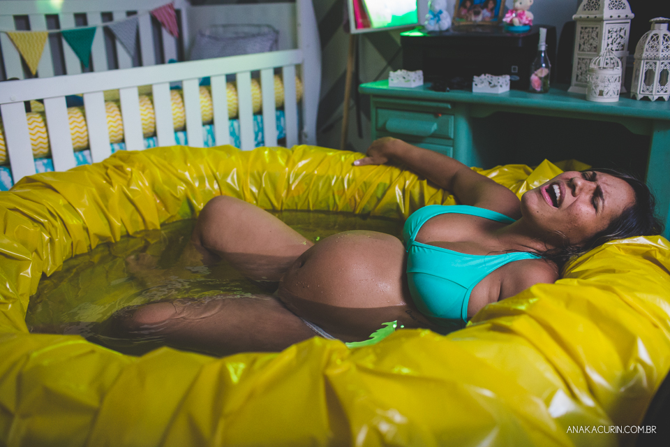 Gestante em trabalho de aprto em casa, mergulhada numa piscina amarela