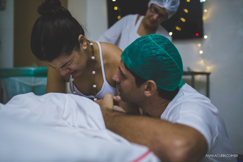 Parto natural hospitalar de Sofia, que aconteceu na Perinatal de Laranjeiras e teve a fotografia feita por Ana Kacurin. Pai sussurra palavras de apoio no ouvido da gestante.