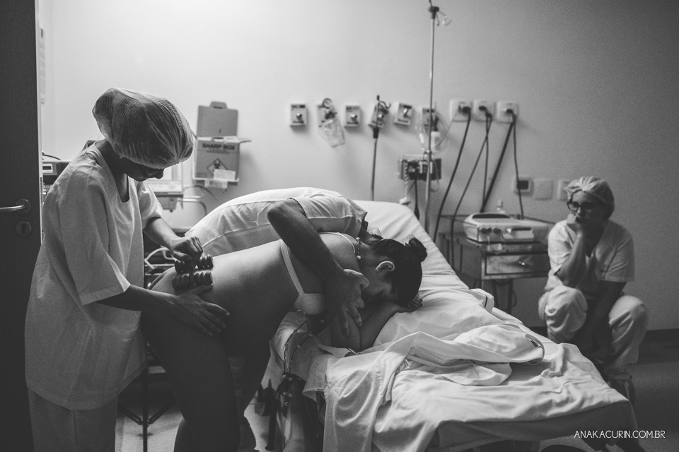 Parto natural hospitalar de Sofia, que aconteceu na Perinatal de Laranjeiras e teve a fotografia feita por Ana Kacurin. Pai apoia e sussurra palavras de carinho e apoio à gestante.