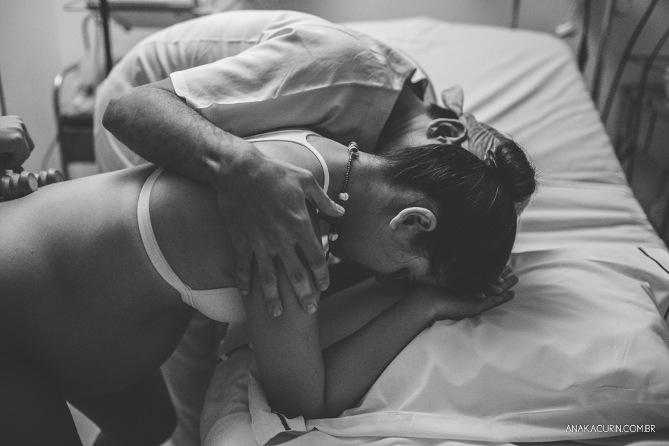 Parto natural hospitalar de Sofia, que aconteceu na Perinatal de Laranjeiras e teve a fotografia feita por Ana Kacurin. Pai apoia e sussurra palavras de carinho e apoio à gestante.