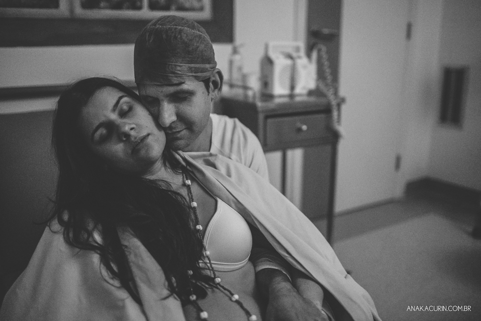 Parto natural hospitalar de Sofia, que aconteceu na Perinatal de Laranjeiras e teve a fotografia feita por Ana Kacurin. Pai abraça gestante ternamente.