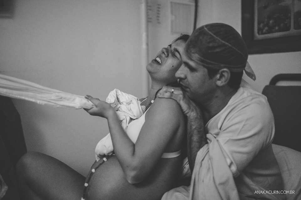 Parto natural hospitalar de Sofia, que aconteceu na Perinatal de Laranjeiras e teve a fotografia feita por Ana Kacurin. Contrações do momento do expulsivo, gestante sustentada por um tecido.