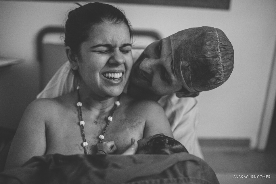 Parto natural hospitalar de Sofia, que aconteceu na Perinatal de Laranjeiras e teve a fotografia feita por Ana Kacurin. Mãe recém parida sorri com bebê no colo.