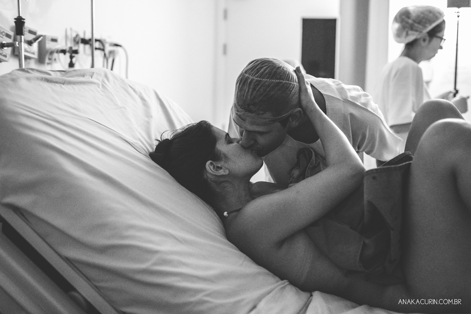 Parto natural hospitalar de Sofia, que aconteceu na Perinatal de Laranjeiras e teve a fotografia feita por Ana Kacurin. Pai beija a mãe recém parida.