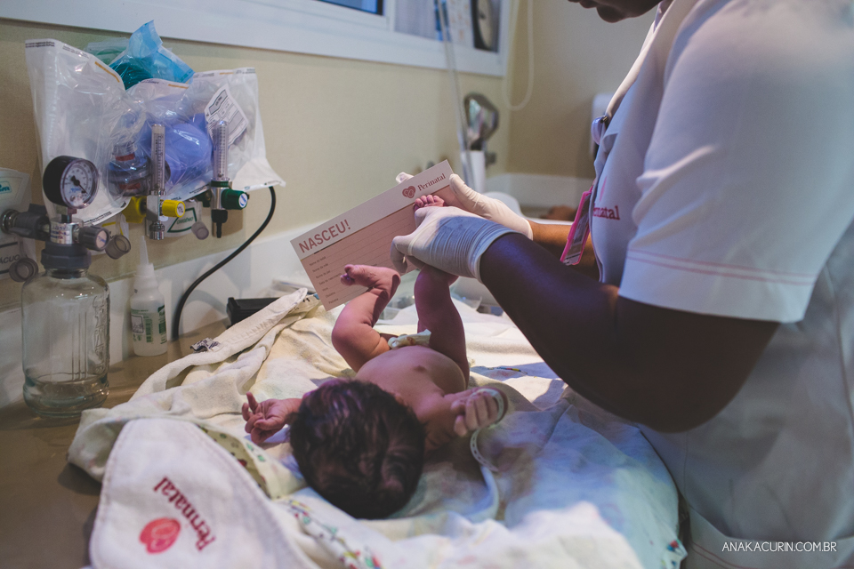Parto natural hospitalar de Sofia, que aconteceu na Perinatal de Laranjeiras e teve a fotografia feita por Ana Kacurin. Bebê tendo pezinho carimbado.