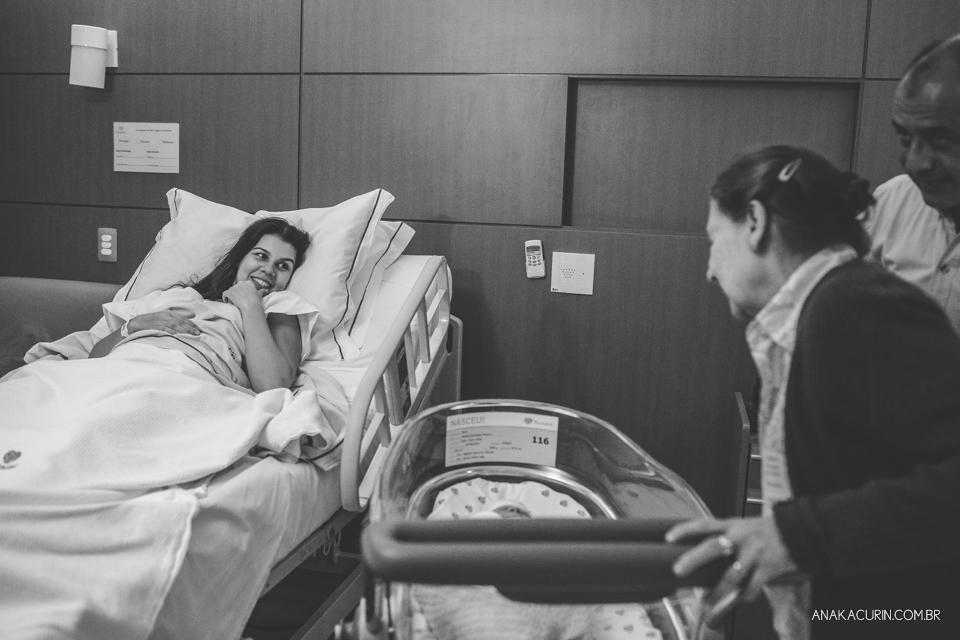 Parto natural hospitalar de Sofia, que aconteceu na Perinatal de Laranjeiras e teve a fotografia feita por Ana Kacurin. Mamãe Amanda recebe bebê no quarto.