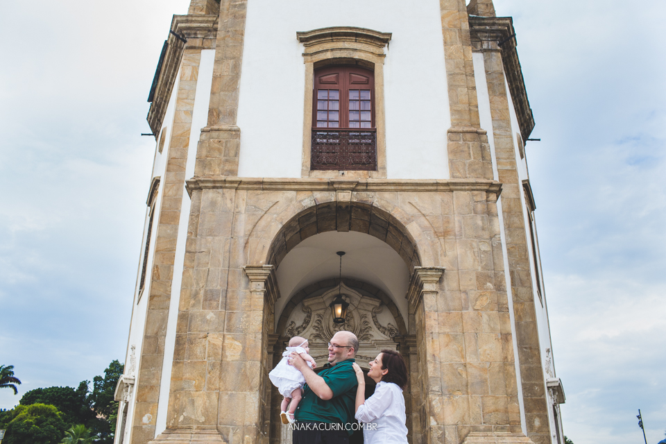 Batizado da Gabi, que aconteceu na igraja Nossa Senhora do Outeiro da Glória, no Rio de Janeiro. Pais seguram bebê e brincam com ela na frente da Igreja.