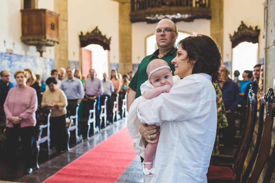 Batizado da Gabi, que aconteceu na igraja Nossa Senhora do Outeiro da Glória, no Rio de Janeiro. Bebê no colo dos pais no altar.