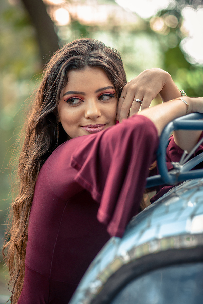 Retrato da linda modelo de olhos verdes usando um vestido vermelho encostada em um fusca durante seu ensaio fotográfico. Foto por Marco Moscarelli Fotógrafo.