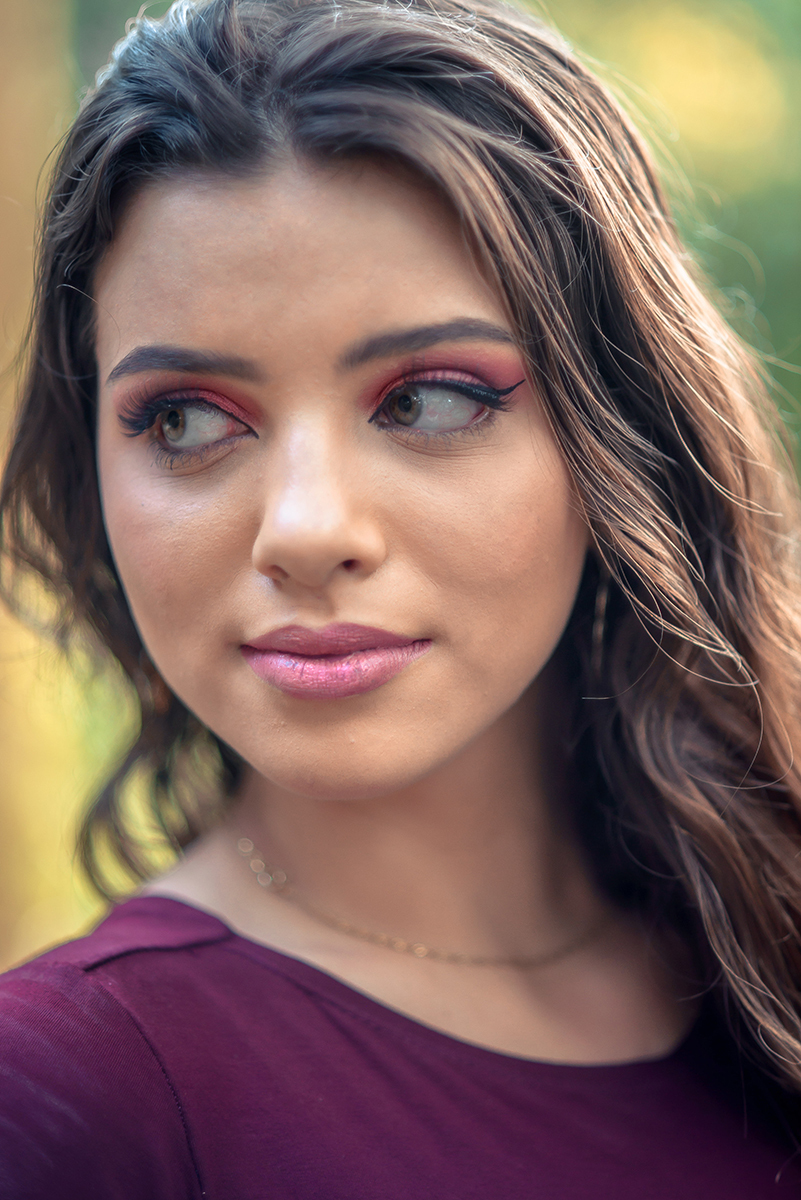 Retrato da linda modelo de olhos verdes usando um vestido vermelho encostada em um fusca durante seu ensaio fotográfico. Foto por Marco Moscarelli Fotógrafo.