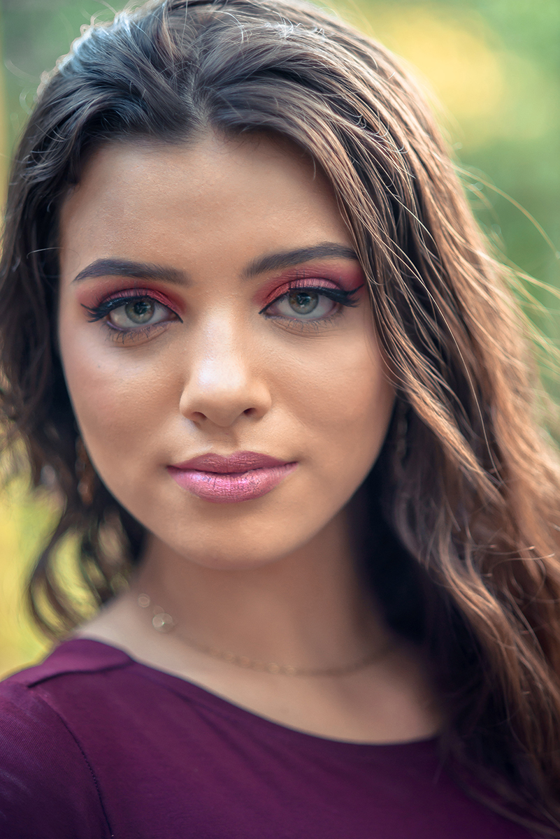 Retrato da linda modelo de olhos verdes usando um vestido vermelho encostada em um fusca durante seu ensaio fotográfico. Foto por Marco Moscarelli Fotógrafo.