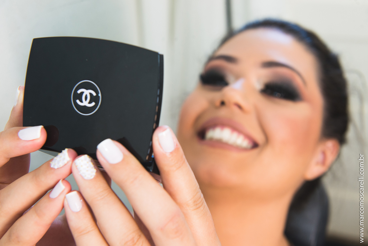 formanda conferindo a maquiagem em espelho de mão