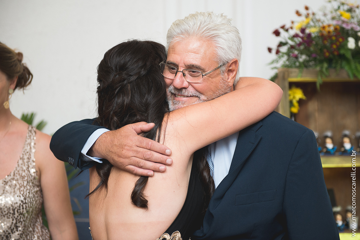 Fromanda abraçando seu pai na recepção de formatura de Marketing