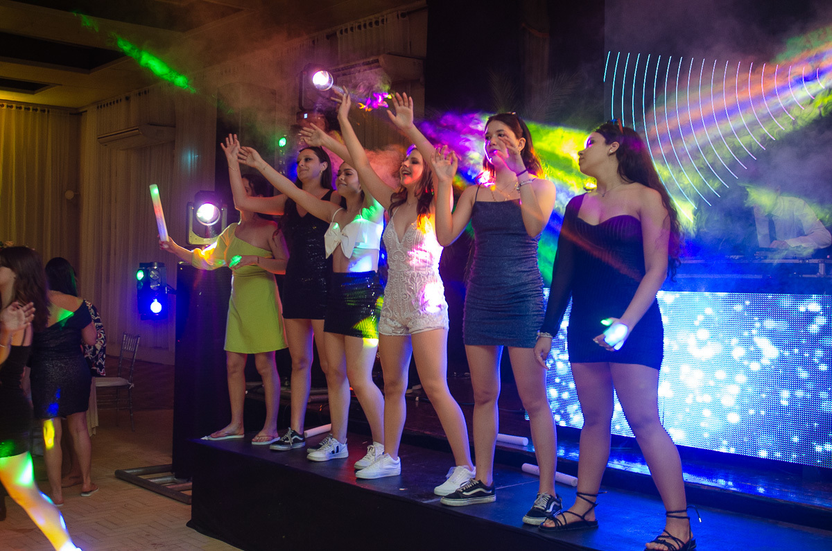 Aniversariante dançando feliz no palco durante o aniversário de 15 anos.  Foto por Marco Moscarelli Fotógrafo Pelotas.