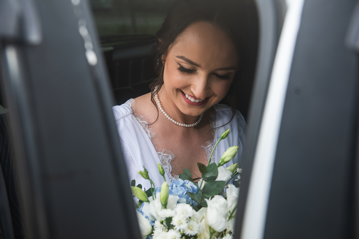 Noiva olhando para o seu buquê no carro antes da cerimônia de casamento. Foto por Marco Marco Moscarelli Fotógrafo
