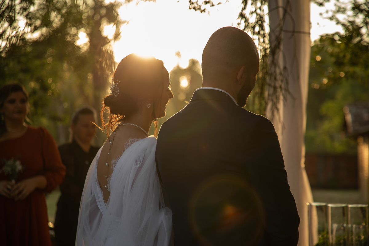 Fotografia em contra luz do casal de noivos durante a cerimônia de casamento ao ar livre. Foto por Marco Marco Moscarelli Fotógrafo