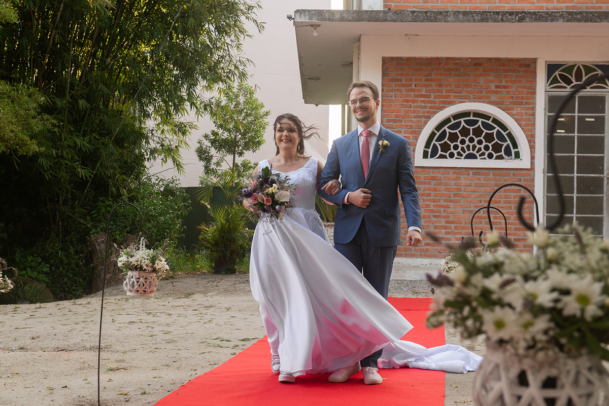 Entrada da noiva conduzida pelo seu irão na cerimônia de casamento ao ar livre em Pelotas. Foto por Marco Moscarelli Fotógrafo.