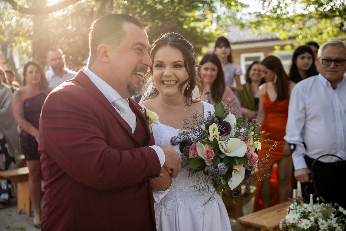 Noivos sorrindo durante a cerimônia de casamento em Pelotas. Foto por Marco Moscarelli Fotógrafo.