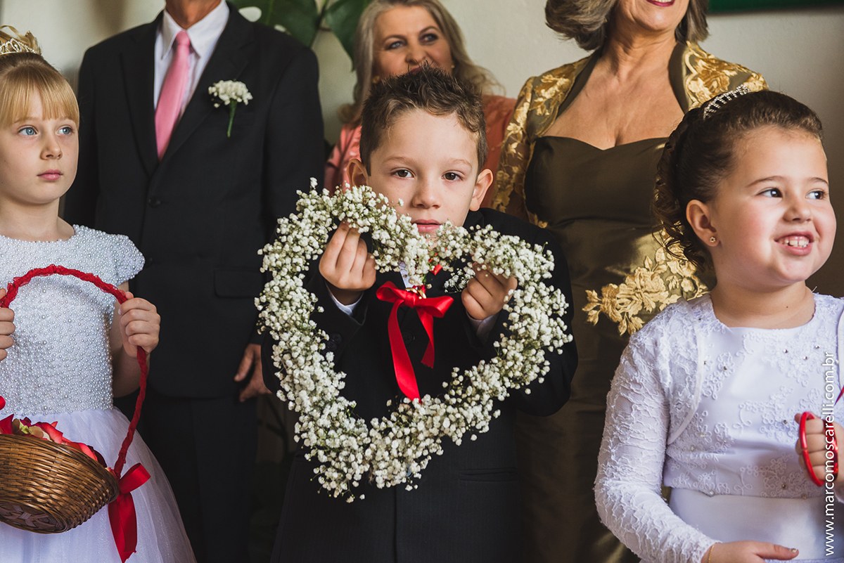 Retrato do pagem do casamento segurando um coração de flores enquanto aguarda a noiva chegar para o casamento. Foto por Marco Moscarelli