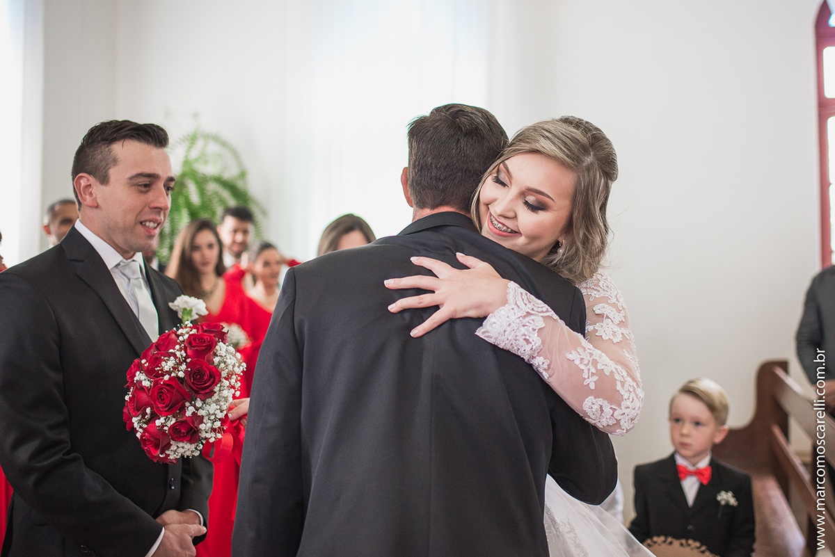 Foto da noiva abraçando o noivo na cerimônia de casamento. Foto por Marco Moscarelli