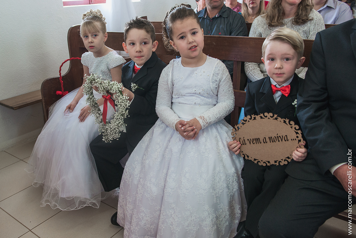Foto dos pagens de das aias sentados em um banco da irgreja durante o casamento. Foto por Marco Moscarelli