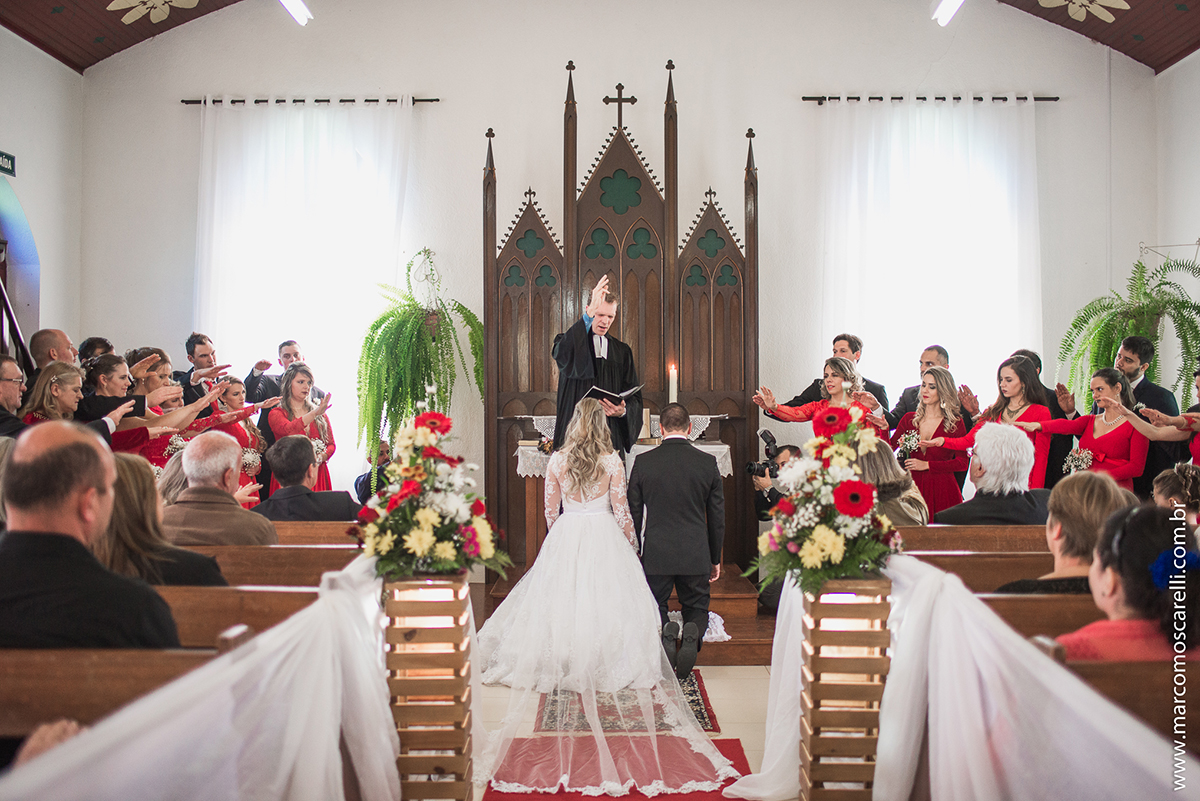 Noivos ajoelhados no altar durtante o casamento. Foto por Marco Moscarelli