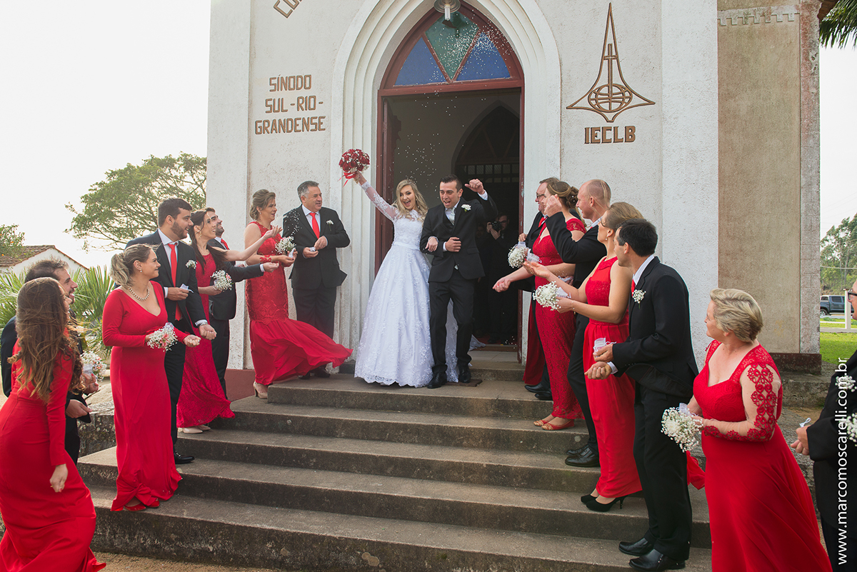 Saida dos noivos da igreja, Noiva levantando o buque para cima com um lindo sorriso. Foto por Marco Moscarelli
