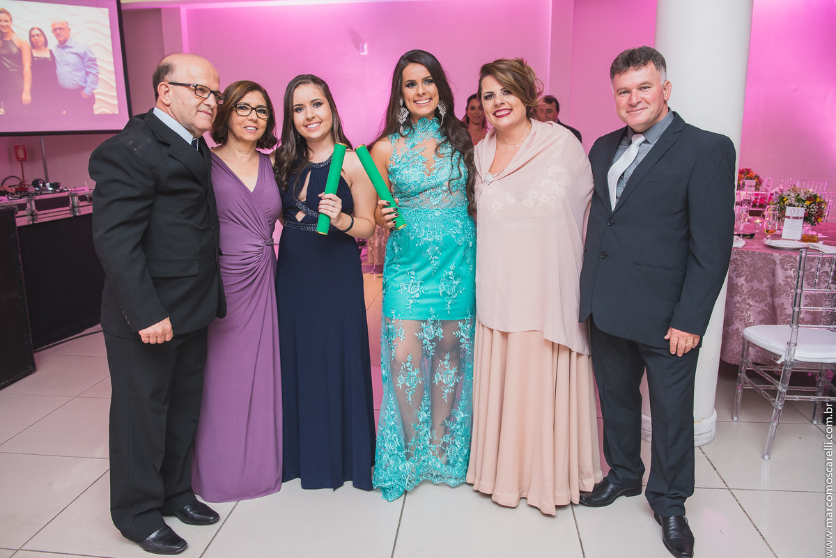 Formandas posando com seus pais logo no começo da recepção de formatura