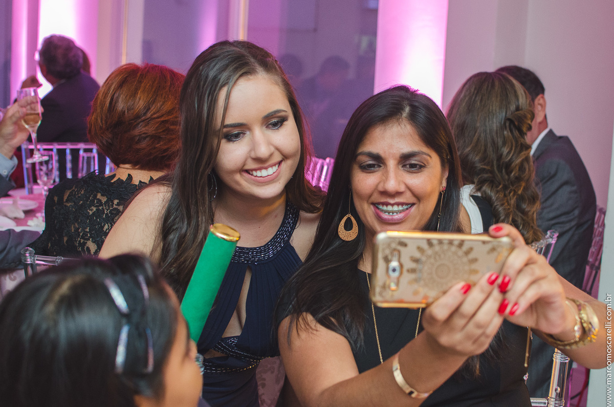 Foto descontraída e espontânea da formanda durante o a festa de formatura. 