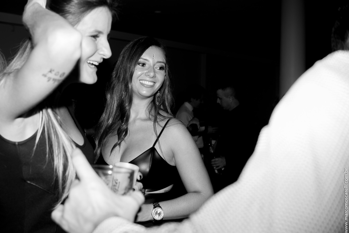 Foto em preto e branco descontraída de uma convidada durante a festa de formatura.