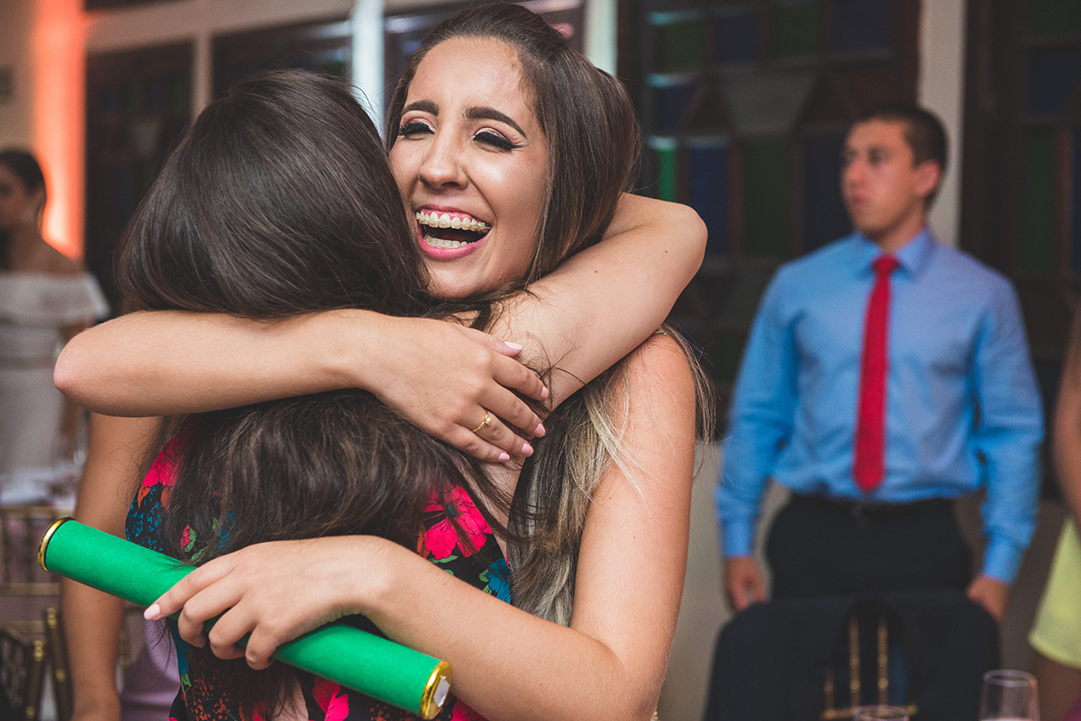 Fotografia do momento em que a formada cumprimenta seus convidados com muitos abraços. Foto por Marco Moscarelli Fotografo