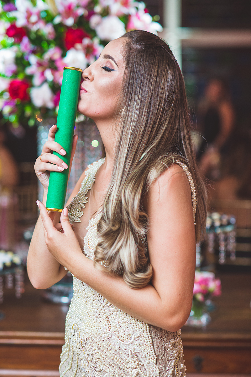 Formanda posando para retrato com seu diploma. Foto por Marco Moscarelli Fotografo
