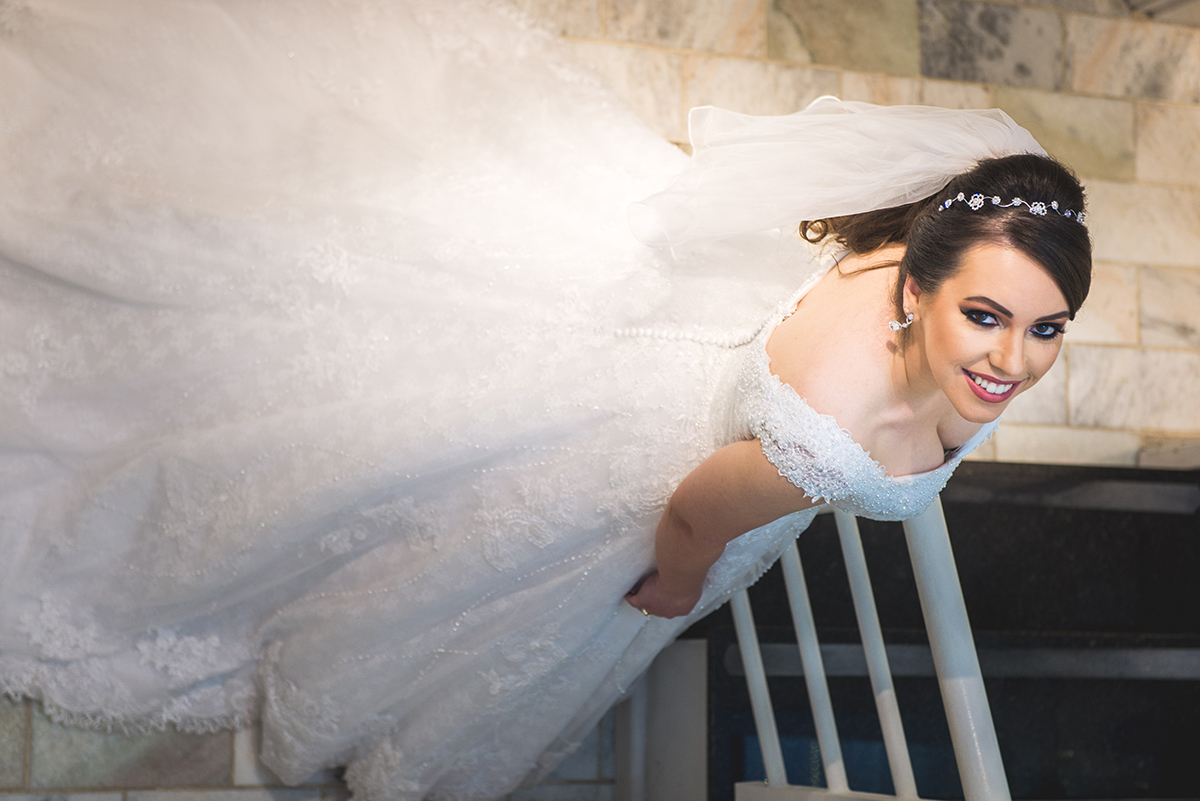 Noiva posando para fotos na escada durante o make da noiva antes do casamento. Foto por Marco Moscarelli Fotografo