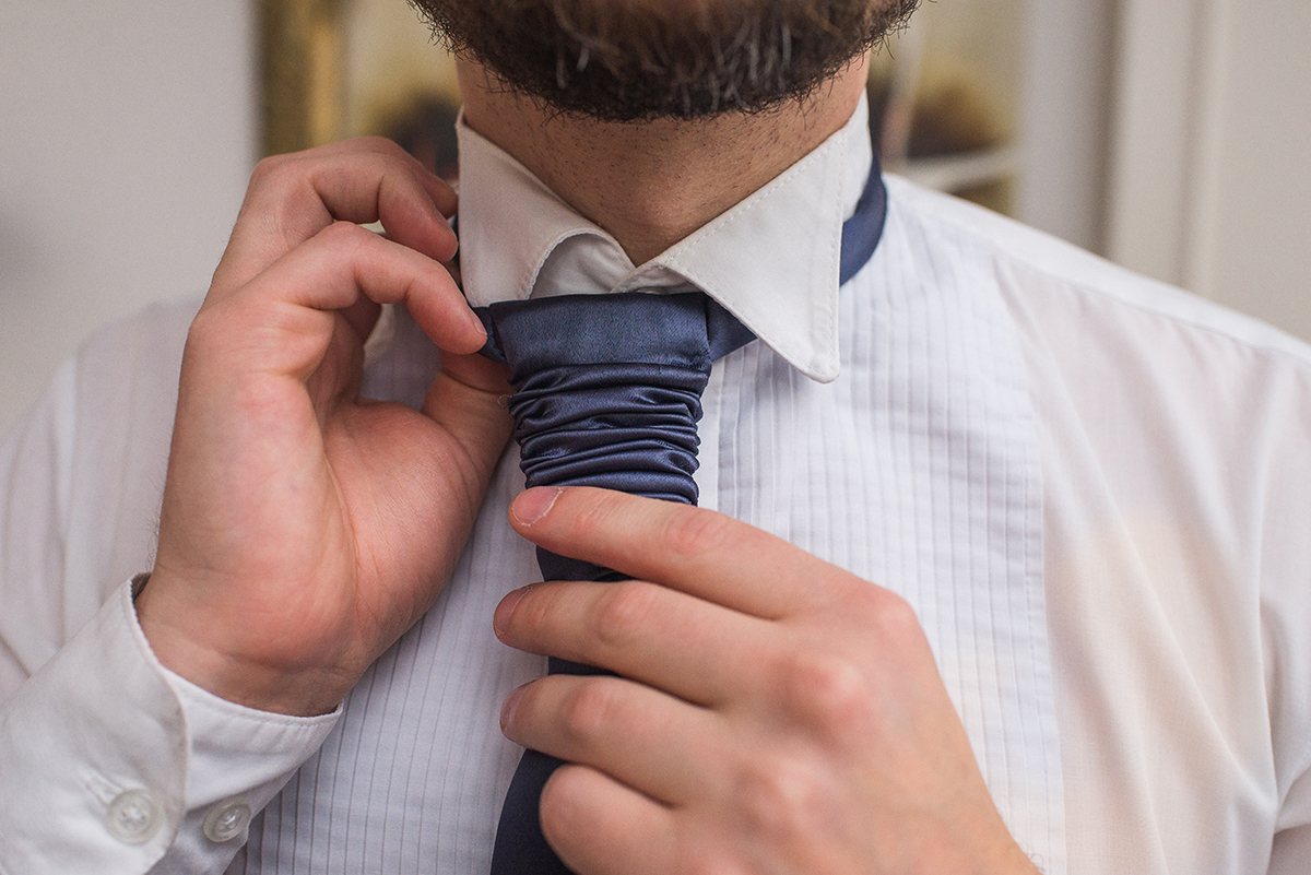 Noivo arrumando a gravata durante os preparativos para o casamento. Foto por Marco Moscarelli Fotografo