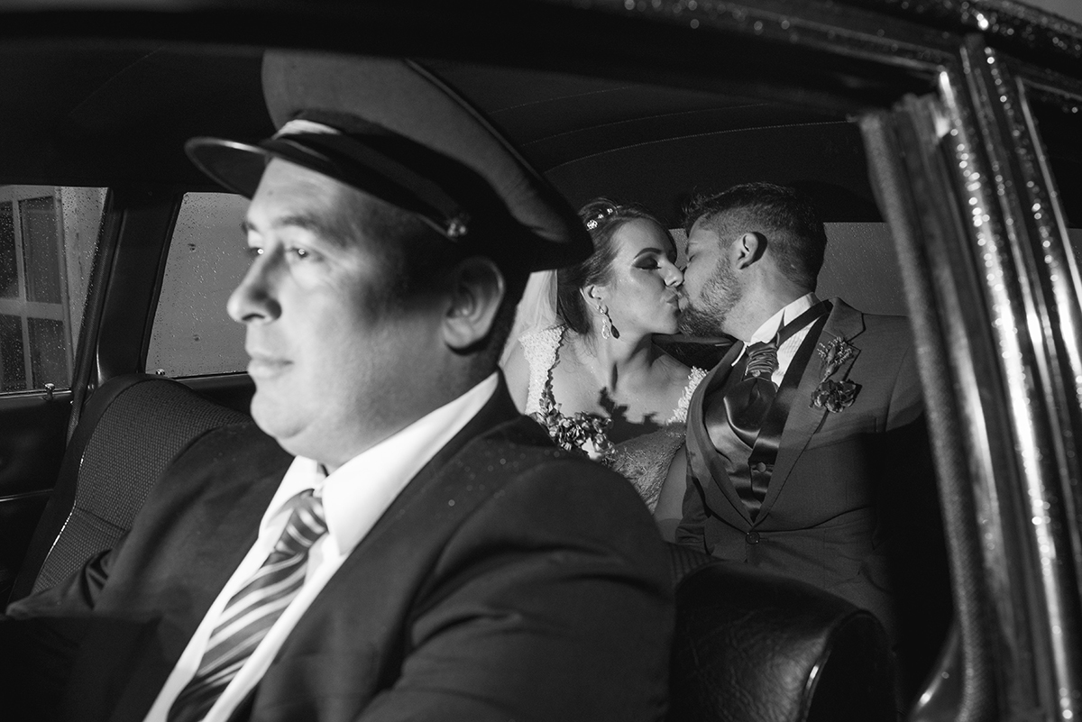 Fotografia em preto e branco dos noivos dentro do carro após a cerimônia de casamento. Foto por Marco Moscarelli Fotografo