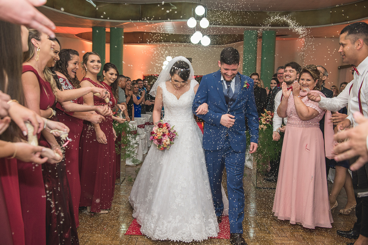 Momento da saida dos noivos da cerimônia de casamento com muita chuva de arroz. Foto por Marco Moscarelli Fotografo