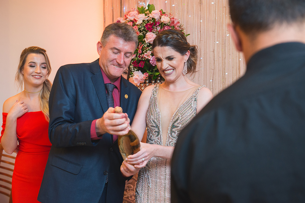 Formanda estourando o espumante com seu pai durante a recepção de medicina. Foto por Marco Moscarelli