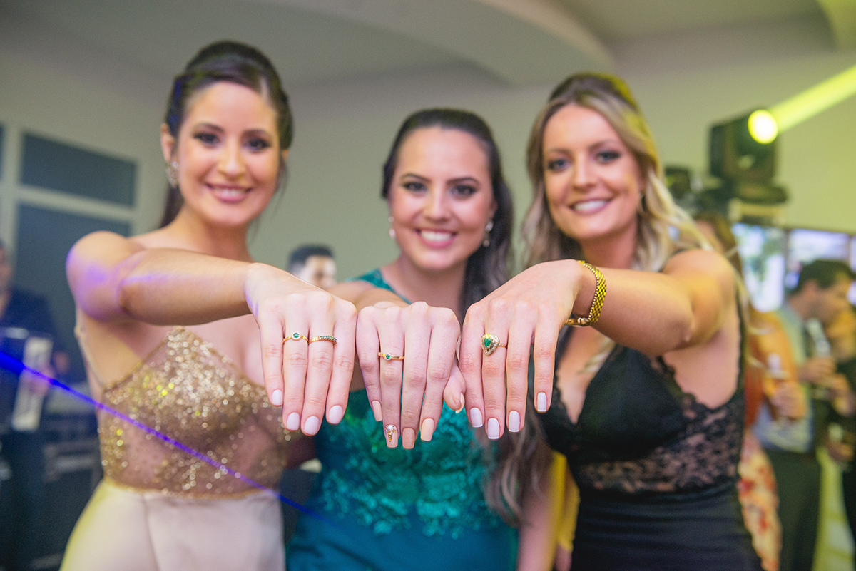 Formanda em medicina fazendo pose divertida com o anel de formatura com suas convidadas. Foto por Marco Moscarelli