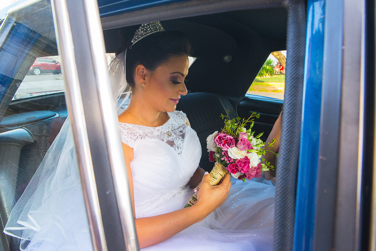 Noiva admirando seu buque momentos antes de desembarcar do carro no dia do seu casamento. Foto por Marco Moscarelli