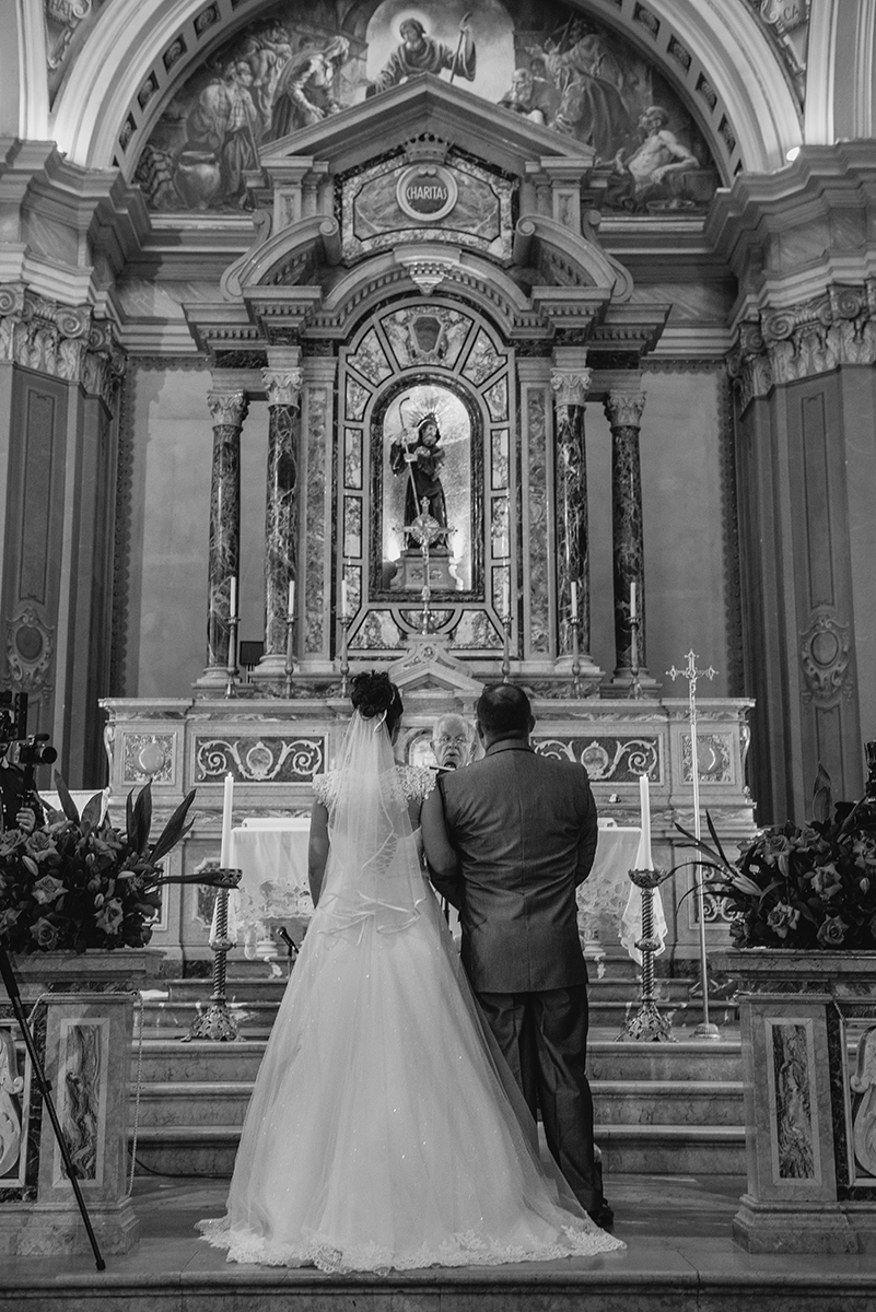 Fotografia em preto e branco  dos noivos no altar durante a cerimônia de casamento. Foto por Marco Moscarelli