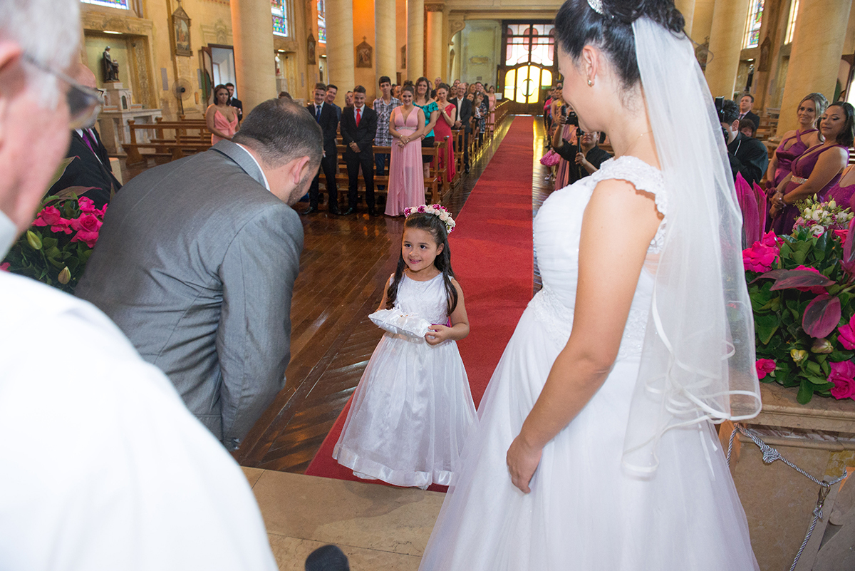Linda aia entrando na igreja carregando as alianças dos noivos durante a cerimônia de casamento. Foto por Marco Moscarelli