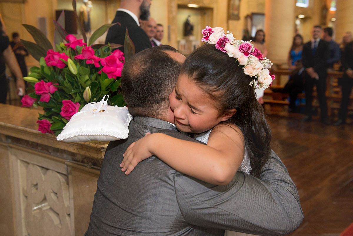 Aia emocionada abraçando o noivo durante a cerimônia de casamento. Foto por Marco Moscarelli