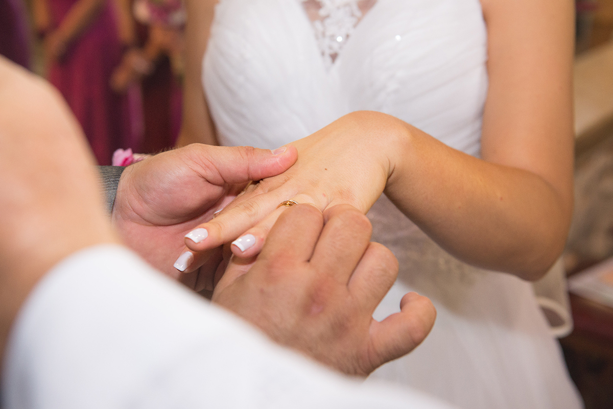 Momento especial em que o noivo coloca a aliança no dedo da noiva durante a cerimônia de casamento. 