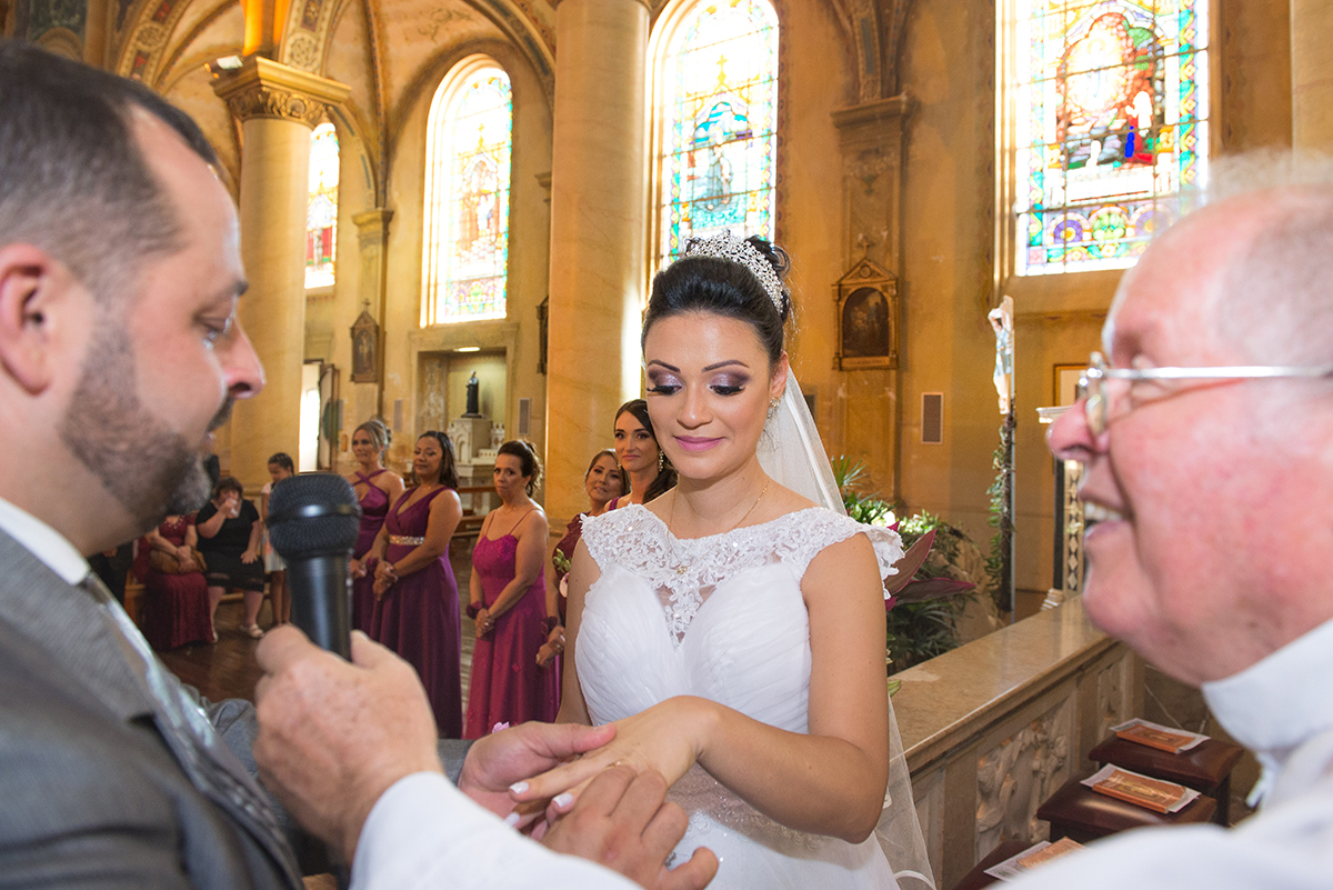 Momento especial em que o noivo coloca a aliança no dedo da noiva durante a cerimônia de casamento. 