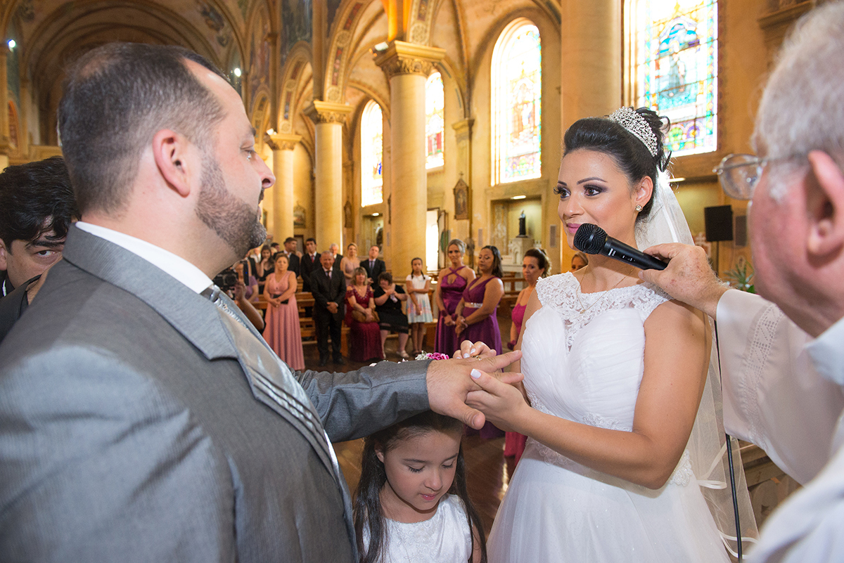 Momento especial em que o noivo coloca a aliança no dedo da noiva durante a cerimônia de casamento. 
